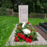 Einzelgrab mit rot-weißer Bepflanzung