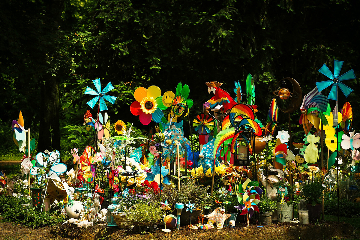 Trauerfeier an geschmücktem Kindergrab