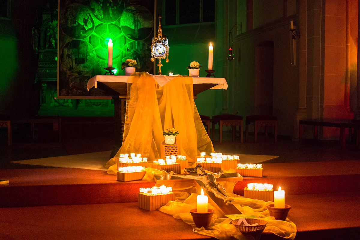 Trauerfeier in einer mit Kerzen geschmückten Kirche