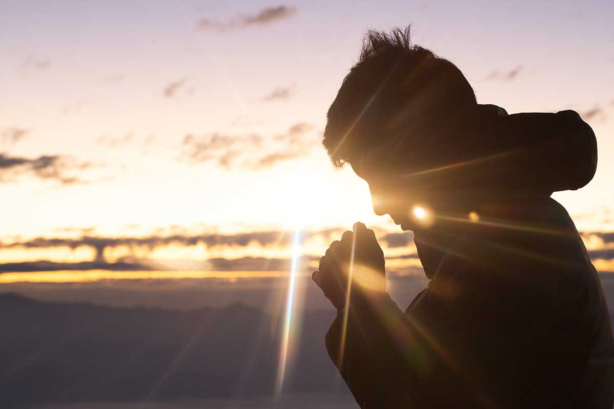 Betender Mann im Sonnenuntergang